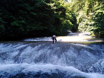 Man surfing on waterfall in forest