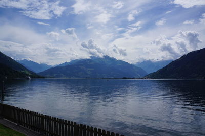 Scenic view of lake by mountains against sky