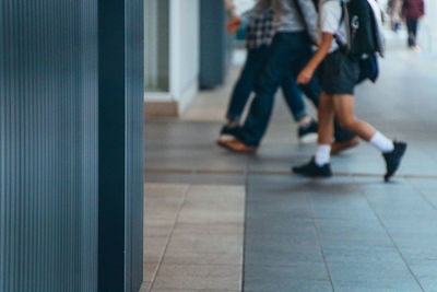 Low section of people walking on tiled floor