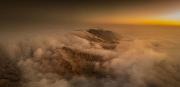 Aerial view of snowcapped mountains against sky during sunset