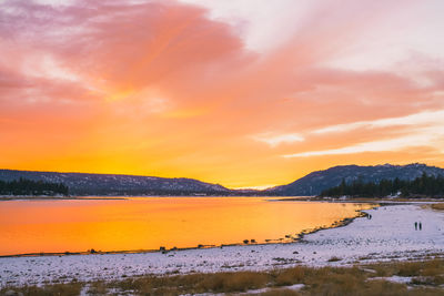 Scenic view of lake against orange sky during sunset