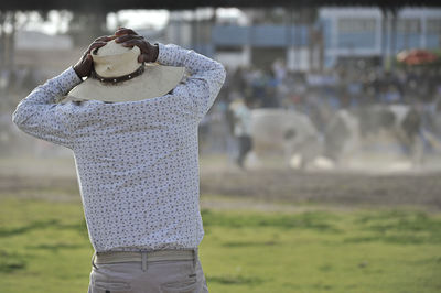 Rear view of man looking at bull fight