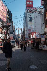 People walking on road against buildings