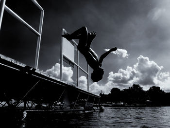 Teenage boy jumping in swimming pool