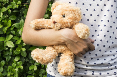 Midsection of woman holding teddy bear