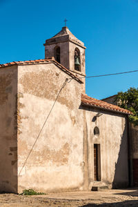 Low angle view of old building against clear blue sky