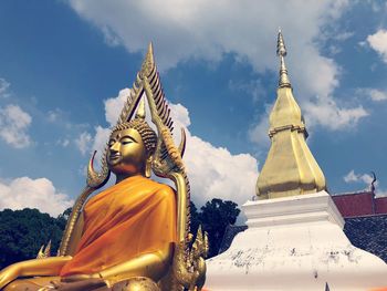 Low angle view of buddha statue against temple