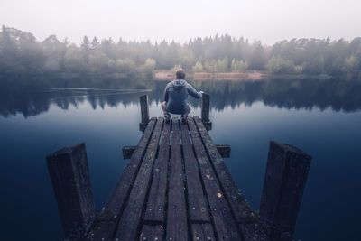 Man on wooden jetty over lake