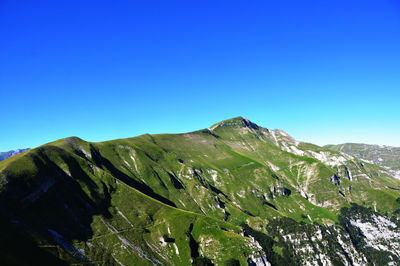 Low angle view of mountain against clear blue sky