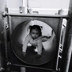 Portrait of cute baby girl in slide tunnel