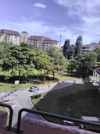 Road by buildings in city against sky