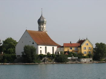 Building by river against sky