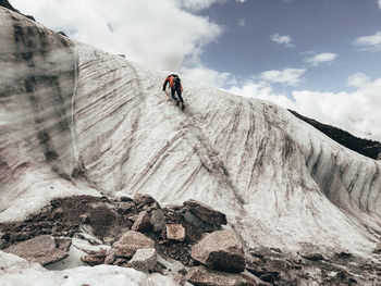 Man surfing on rock in mountains against sky