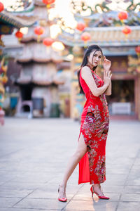 Full length of woman standing on footpath