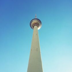 Low angle view of communications tower against blue sky