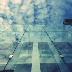 Low angle view of modern building against cloudy sky