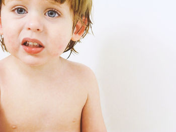 Portrait of shirtless boy against white background