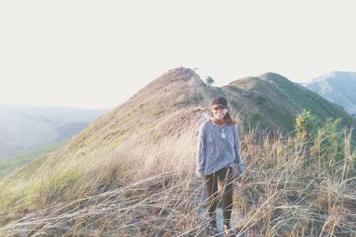 Full length of man standing on mountain against sky