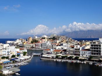 View of buildings in sea against cloudy sky