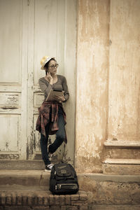 Portrait of woman standing against wall