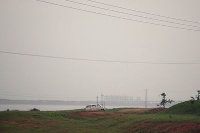 Electricity pylon on field against sky