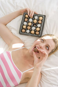 Woman eating chocolate at home