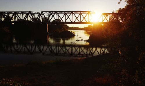 Bridge over river at sunset