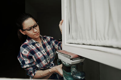 A young girl using a sander. concept of female empowerment