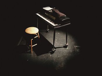 Piano and stool in dark room