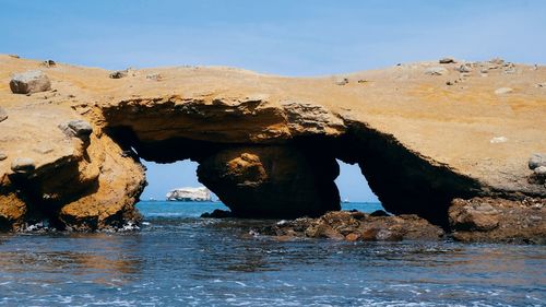 Rock formation in sea against sky