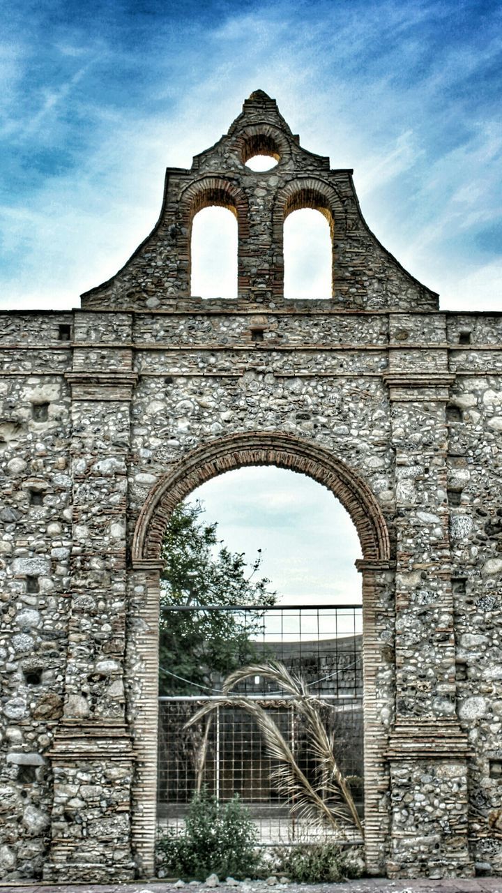 architecture, built structure, arch, building exterior, low angle view, sky, history, window, old, stone wall, brick wall, day, arched, the past, entrance, cloud - sky, outdoors, cloud, wall - building feature, no people