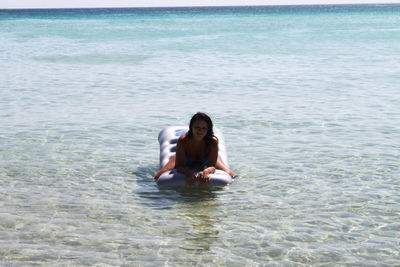 Portrait of young woman sitting in sea