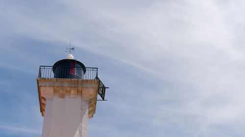 Low angle view of lighthouse on building against sky