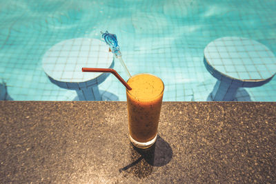 Close-up of drink on table at swimming pool