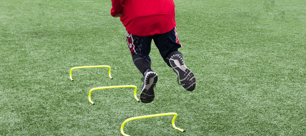 Low section of man playing soccer on field