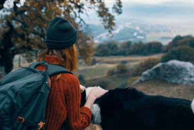 Rear view of woman with dog looking at view