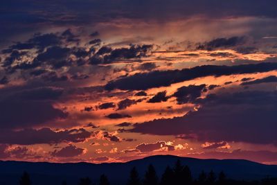 Low angle view of silhouette mountains against dramatic sky