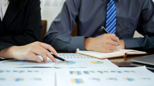 Midsection of business people working at office
