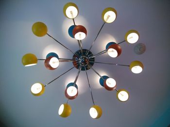 Low angle view of illuminated light bulb hanging on ceiling