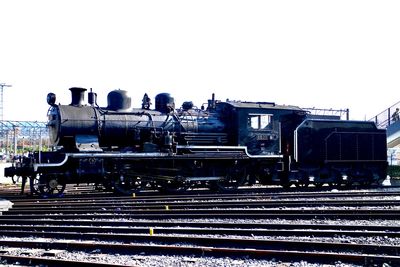Train on railroad track against clear sky