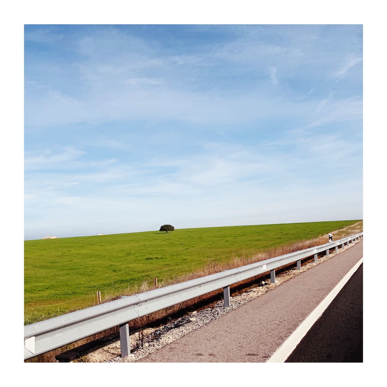 SCENIC VIEW OF ROAD AMIDST FIELD AGAINST SKY