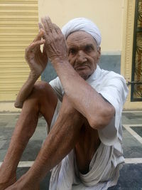 Portrait of senior man sitting on walkway