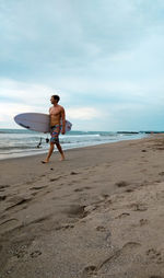 Full length of shirtless man on beach