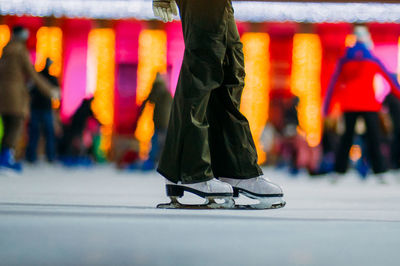 Low section of person ice-skating at night