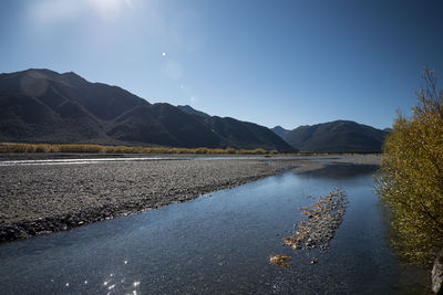 Scenic view of lake and mountains against blue sky