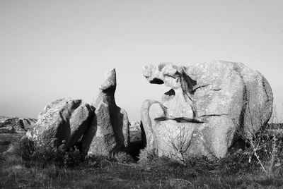 Statue on field against clear sky