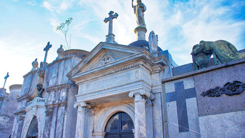 Low angle view of statues on building against sky