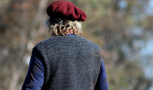 Rear view of man wearing sweater while standing outdoors