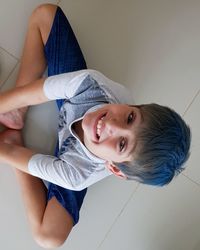 Portrait of cute smiling boy on tiled floor at home