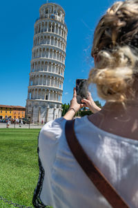 Portrait of woman in front of historic building against sky